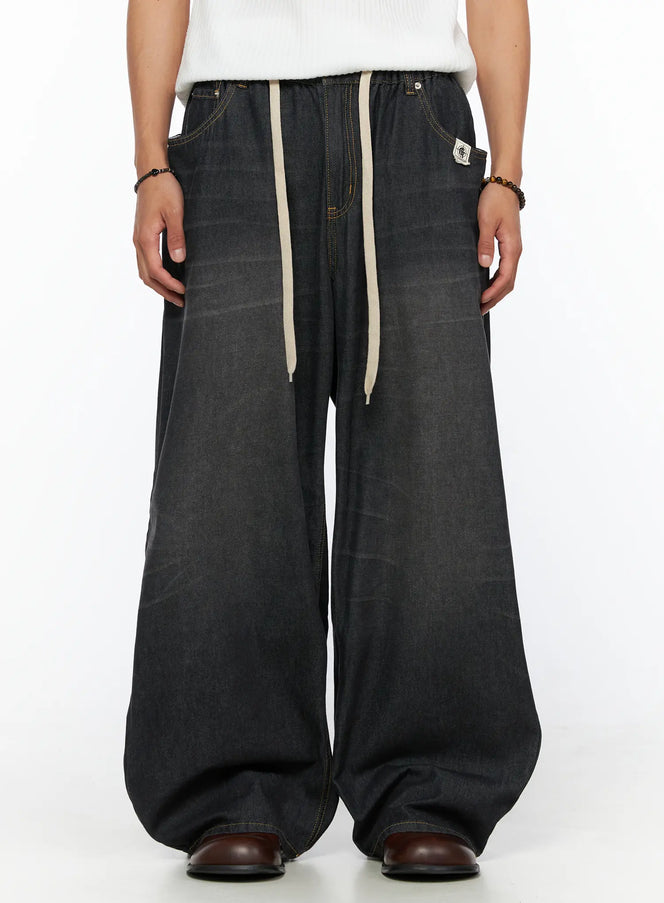 LEWKIN Men's Bryan Drawstring Baggy Jeans IL520 Black size M/L front crop shot on model wearing white top, cream drawstring, faded black denim