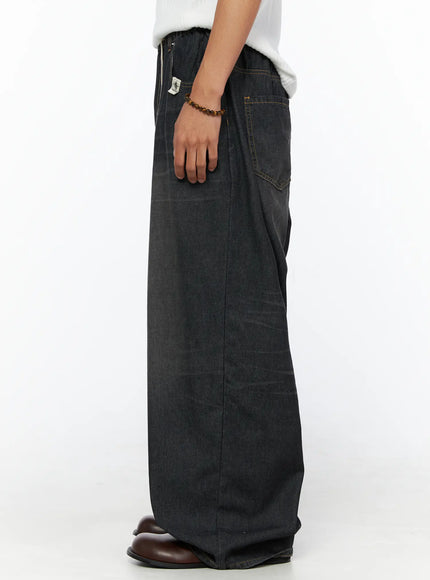 Men's Bryan Drawstring Baggy Jeans IL520 Black side shot on model showing ultra-wide leg profile, elastic waistband, faded black denim texture, brand label