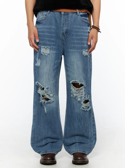 LEWKIN Men's Bryce Ripped Straight-Fit Jeans IL520 Blue front close-up on model showing large distressed knee tears and frayed holes with braided belt