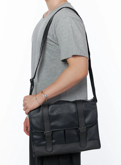 Men's Buckle Crossbody Bag IU523 Black side shot on male model wearing gray tee and pinstripe trousers carrying bag on shoulder