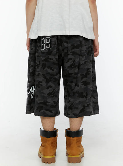 Men's Camo Graphic Shorts (Dark Gray) IL509 Dark gray back view on model showing 89 embroidered numeral on back pocket and wide boxy cut with camo print