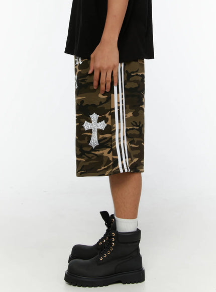 Men's Camo Graphic Sweat Shorts IL515 Beige opposite side view on model showing large crackle-texture cross print and white side stripe detail