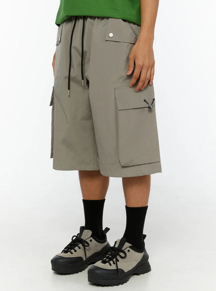 Men's Cargo Bermuda Shorts (Gray) IL509 Gray side view on model showing right cargo pocket with toggle clasp and snap-button front pocket detail