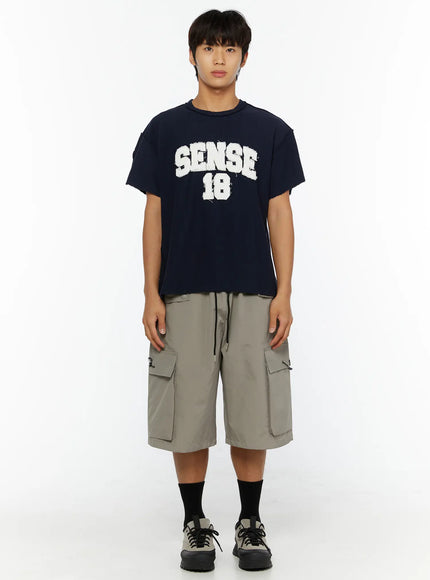 Men's Cargo Bermuda Shorts (Gray) IL509 Gray full-body front shot on male model wearing navy SENSE 18 graphic tee and chunky sneakers