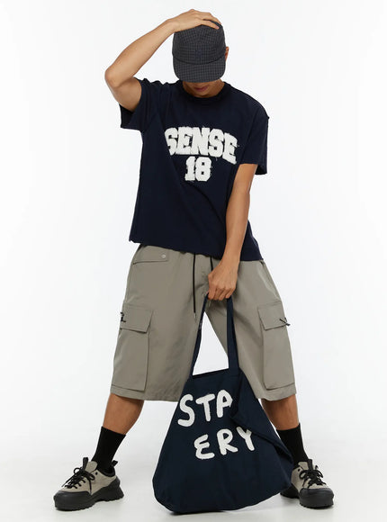 Men's Cargo Bermuda Shorts (Gray) IL509 Gray full-body front shot on male model bending forward with cap and navy tote bag, cargo pocket details visible