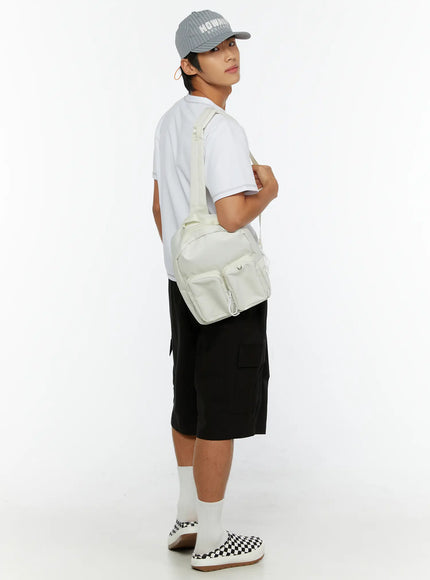 Men's Cargo Bermuda Shorts IL513 Black three-quarter back view on male model with white polo, cream multi-pocket crossbody bag, and gray Howard cap