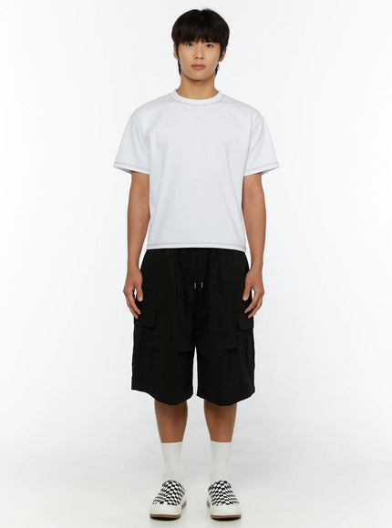 Men's Cargo Bermuda Shorts IL513 Black full-body front view on male model with white crewneck tee, standing straight, drawstring waistband and large cargo pockets visible