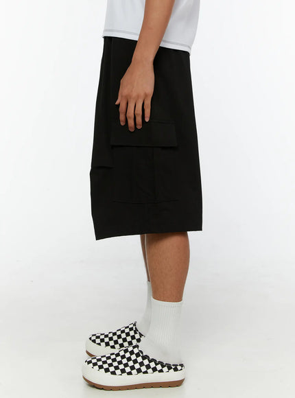 Men's Cargo Bermuda Shorts IL513 Black side view on male model showing cargo pocket depth, elasticated waistband, and below-knee length silhouette