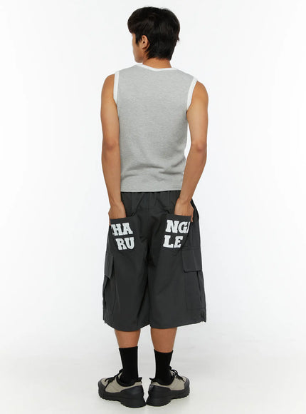 LEWKIN Men's Cargo Jorts IL510 Dark gray back view on male model size M/L hands in pockets showing CHANGE RULE letter print on rear pockets