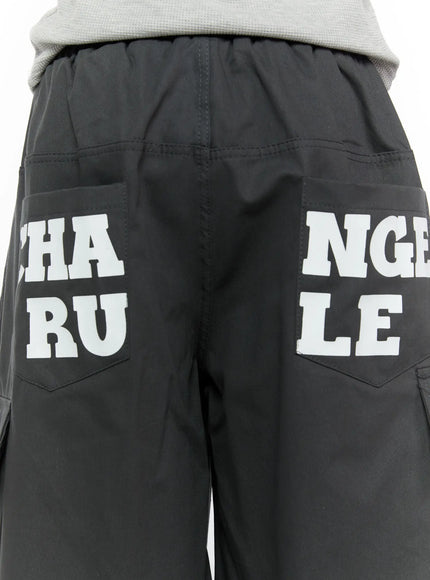 Men's Cargo Jorts IL510 Dark gray back view on male model showing full CHANGE RULE white letter print on rear pockets side cargo pockets visible