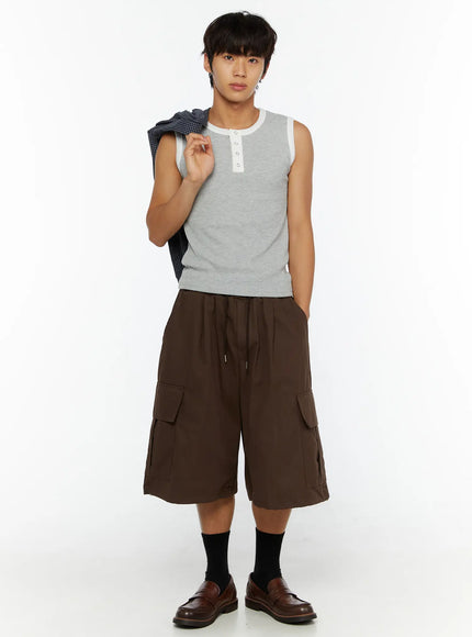 Men's Cargo Pocket Jorts IL510 Dark brown front view on male model in gray henley sleeveless top holding plaid shirt over shoulder styled with black socks and loafers