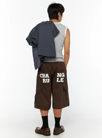 Men's Cargo Pocket Jorts IL510 Dark brown back view on male model wearing gray sleeveless top with plaid shirt draped over shoulder and brown loafers