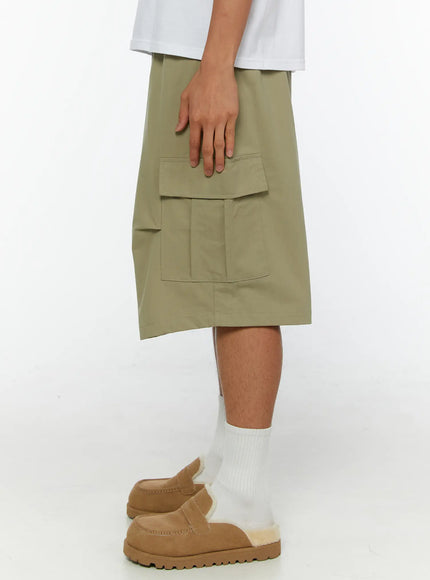 Men's Cargo Shorts IL513 Dark green close-up side detail view on model highlighting large flap cargo pocket structure and smooth nylon fabric texture