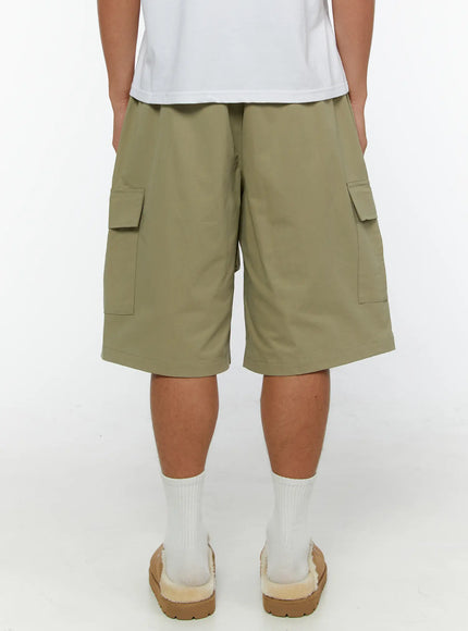 Men's Cargo Shorts IL513 Dark green back view on male model showing rear cargo pockets, elastic waistband, wide-leg silhouette, loafers and white socks