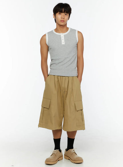 Men's Cargo Street Jorts IL510 khaki front full-body shot on male model standing upright with hands in pockets styled with gray tank top and beige shoes