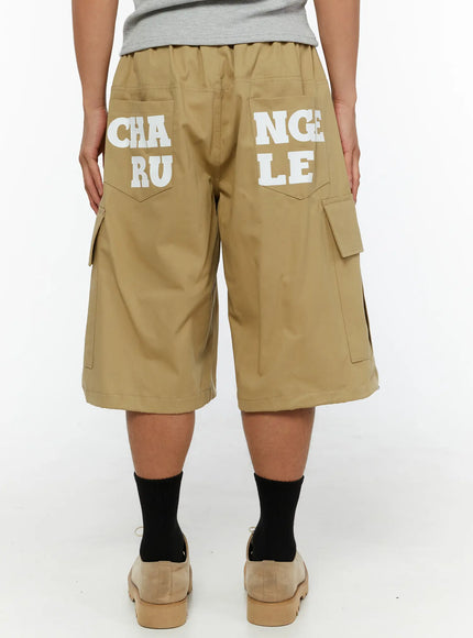 Men's Cargo Street Jorts IL510 khaki back shot on male model standing showing full CHANGE RULE graphic print across rear pockets and side cargo pockets