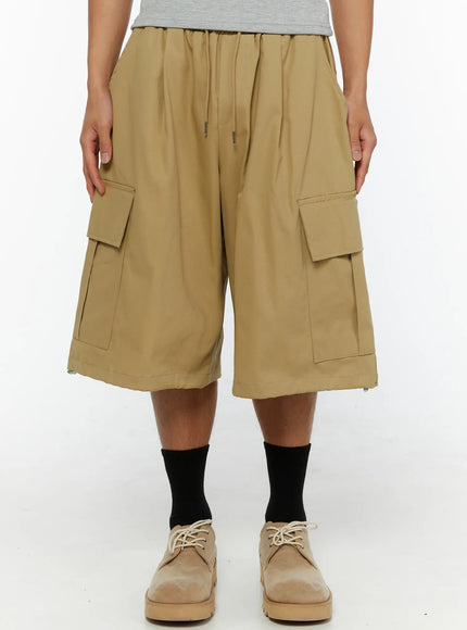 Men's Cargo Street Jorts IL510 khaki front close-up shot on male model showing elastic drawstring waistband and dual flap cargo pockets wide-leg silhouette