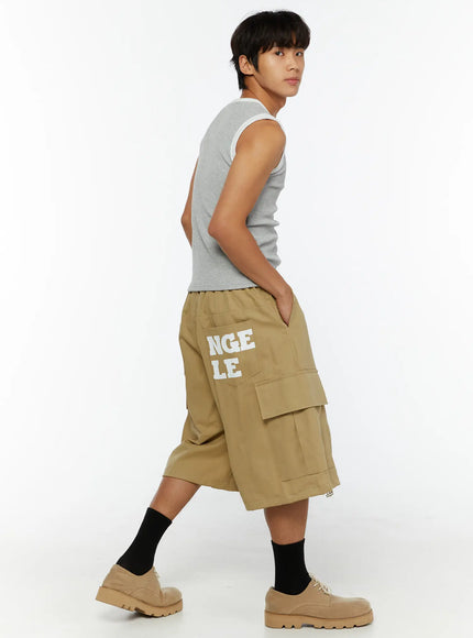 LEWKIN Men's Cargo Street Jorts IL510 khaki side-angle shot on male model walking pose showing right-side graphic text print and cargo pocket detail