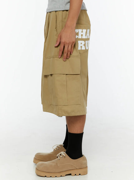 Men's Cargo Street Jorts IL510 khaki left-side close-up shot on male model showing layered cargo pocket flap construction and hem zipper detail