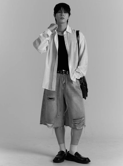 Men's Casual Button-Up Shirt IL502 white full-body black and white editorial shot on model wearing flat cap, open over black tank with ripped denim shorts and crossbody bag