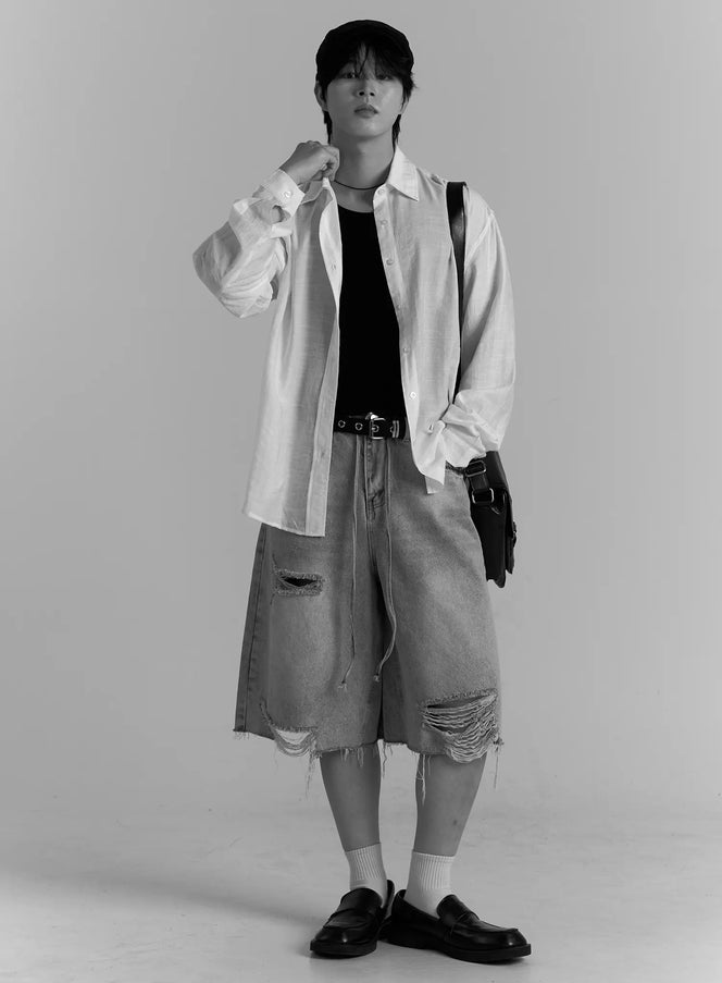 Men's Casual Button-Up Shirt IL502 white full-body black and white editorial shot on model wearing flat cap, open over black tank with ripped denim shorts and crossbody bag