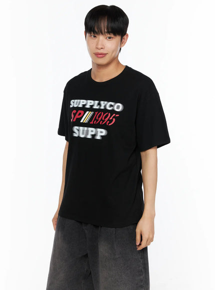 Men's Casual Graphic Tee IL514 Black angled close-up front shot on male model showing SUPPLYCO SP1995 SUPP graphic print detail
