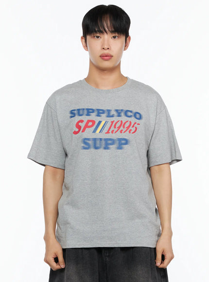 Men's Casual Graphic Tee IL514 Gray front upper-body close-up on male model showing SUPPLYCO SP1995 SUPP graphic print on heathered cotton fabric