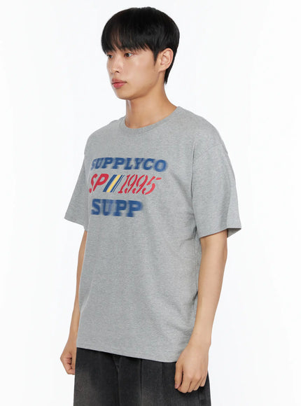 Men's Casual Graphic Tee IL514 Gray side-angle upper-body shot on male model showing SUPPLYCO SP1995 SUPP graphic print and relaxed cotton fit