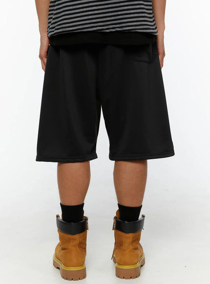 Men's Casual Jorts IL510 Black back shot on model showing back pocket detail, wide relaxed fit, and clean hemline with tan boots