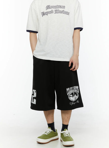 Men's Casual Number Print Shorts (Black) IL509 Black back view on model styled with white graphic tee, displaying both number 2 and collegiate circle prints on wide-leg shorts