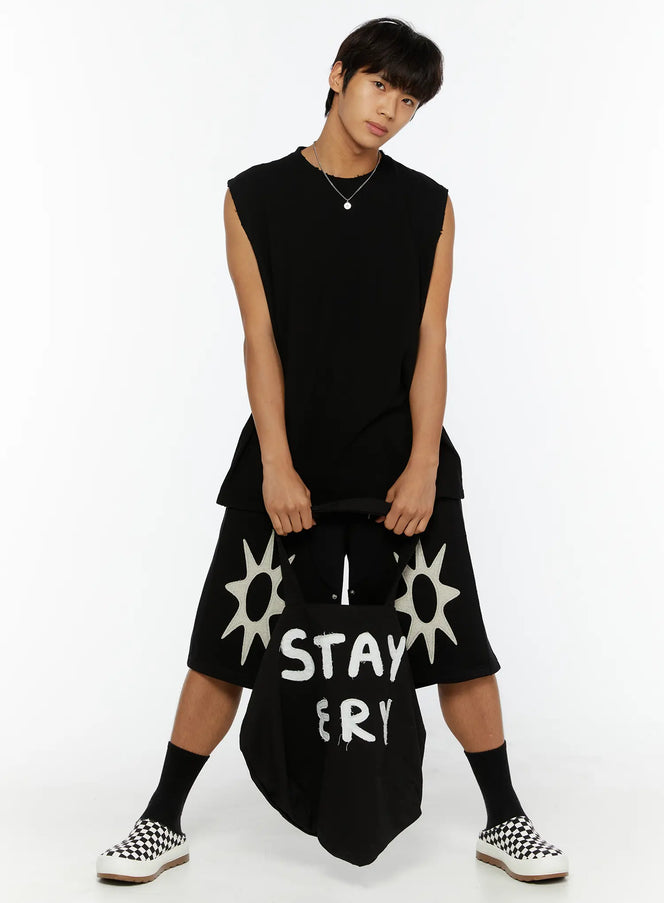 Men's Casual Sleeveless Top IL510 Black full-body front shot on male model holding tote bag, styled with sun-print shorts and checkered slip-ons
