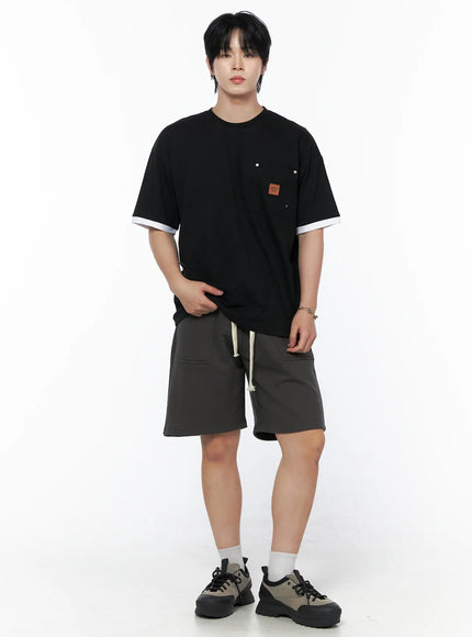 Men's Casual Sweat Shorts (Dark Gray) IL502 Dark Gray full-body front on male model standing straight, styled with black layered tee and chunky sneakers with white socks