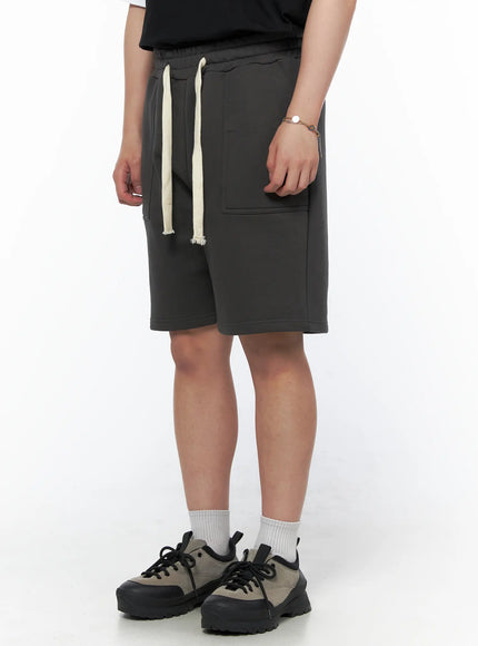 Men's Casual Sweat Shorts (Dark Gray) IL502 Dark Gray side-angle on model showing cream drawstring detail and side pocket, paired with black tee and sneakers