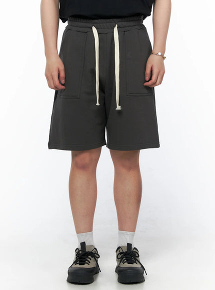 Men's Casual Sweat Shorts (Dark Gray) IL502 Dark Gray front on model cropped at waist, showing elastic waistband, cream drawstring, and dual patch front pockets