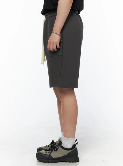 Men's Casual Sweat Shorts (Dark Gray) IL502 Dark Gray side view on model showing smooth fleece fabric silhouette, side pocket seam, and cream drawstring detail