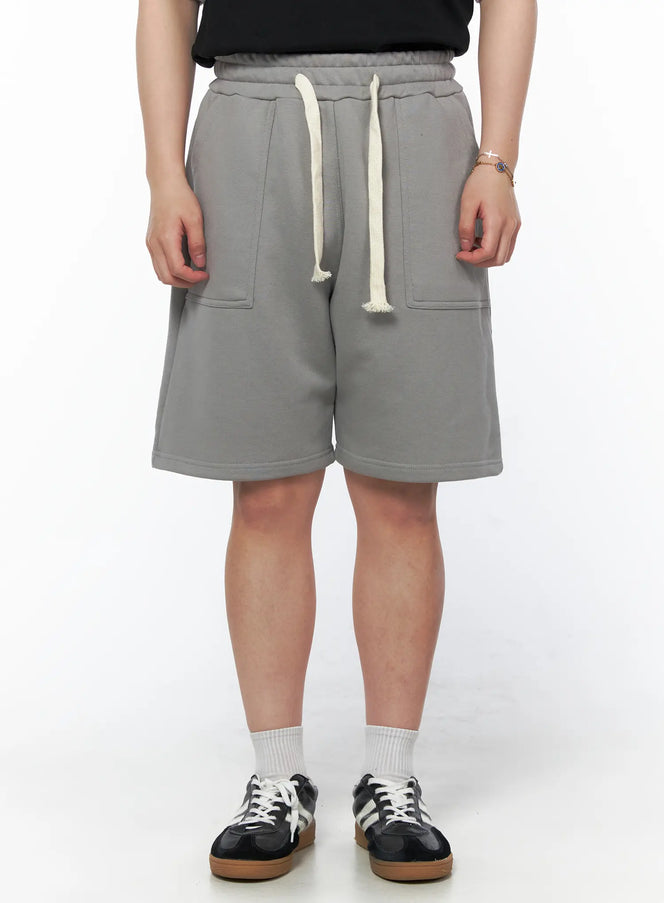 LEWKIN Men's Casual Sweat Shorts (Gray) IL502 gray front view on model with cream drawstring waistband and patch pockets paired with black tee and sneakers