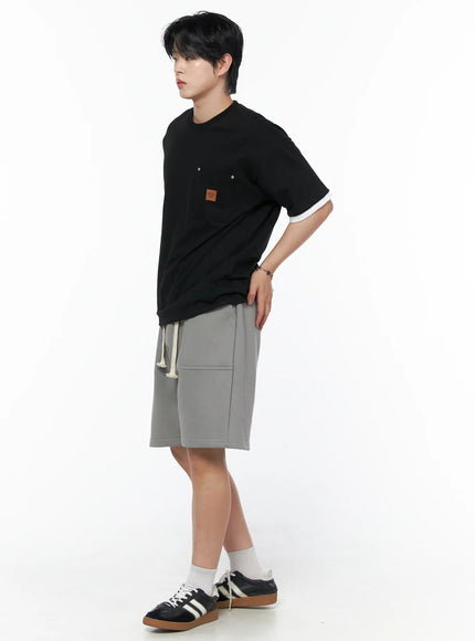 Men's Casual Sweat Shorts (Gray) IL502 gray full-body side view on male model with hands on hip showing relaxed wide-leg silhouette and knee-length hem