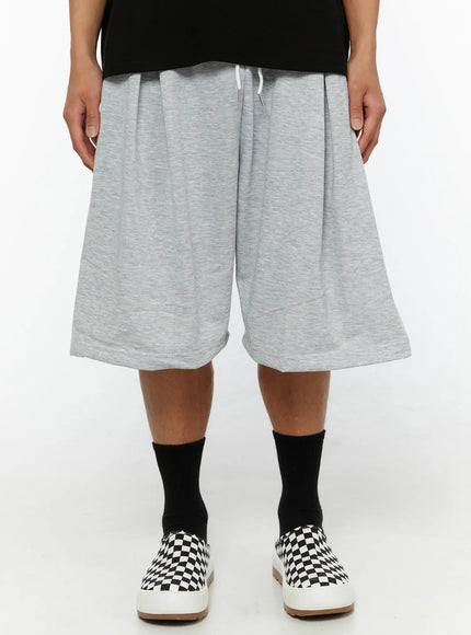 LEWKIN Men's Casual Sweat Shorts IL510 gray front view on male model wearing black tee and checkered slip-on sneakers, wide-leg silhouette with white drawstring