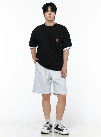 Men's Casual Sweat Shorts (Light Gray) IL502 Light Gray full-body front view on male model standing upright, styled with black graphic tee and chunky sneakers, relaxed fit sweat shorts