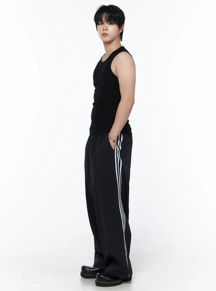 Men's Casual Tank IL502 Black side view on model showing white stripe detail on wide-leg pants, tank tucked at waist, chunky boots