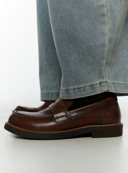 Men's Classic Antique Loafers IL507 Dark brown side close-up on model showing profile penny strap stitched moc-toe and stacked heel styled with light blue jeans