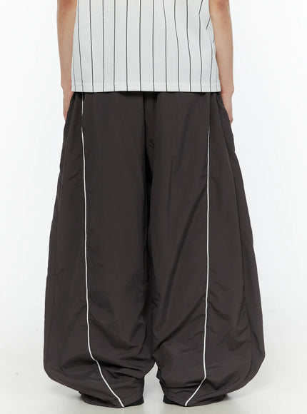 Men's Contrast Piping Nylon Track Pants (Dark Gray) IL507 Dark gray back shot on model showing rear view of wide balloon-leg silhouette with double white piping seams and gathered hem