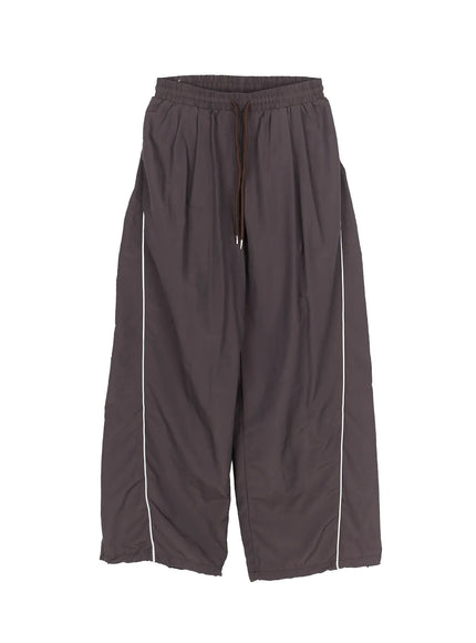Men's Contrast Piping Nylon Track Pants (Dark Gray) IL507 Dark gray flat-lay front view showing elastic drawstring waist wide-leg nylon construction and white contrast piping along both sides