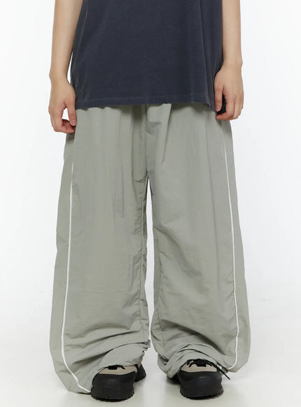 LEWKIN Men's Contrast Piping Nylon Track Pants (Gray) IL507 Gray front close-up on model showing wide-leg silhouette with white piping detail and pooling hem