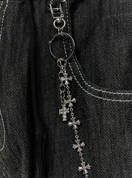 Men's Cross-Link Chain IL509 Silver close-up detail shot showing silver ring clasp and cascading cross charms clipped to dark denim pocket seam