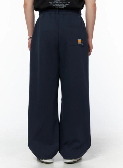 LEWKIN Men's Curved Fit Sweatpants (Dark Blue) IL502 Dark blue back view on model showing Universal 91 patch on back pocket and wide-leg silhouette