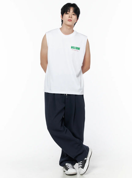 Men's Curved Fit Sweatpants (Dark Blue) IL502 Dark blue full front view on male model leaning casually in white sleeveless top showing draped wide-leg fit