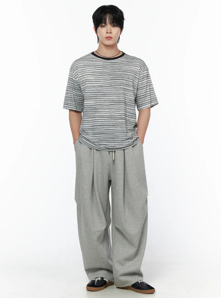 Men's Curved Fit Sweatpants (Gray) IL502 gray front full-body shot on male model with hands in pockets wearing striped tee and black shoes