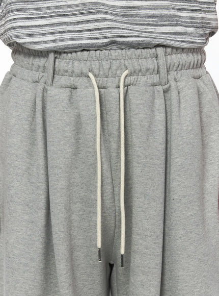 Men's Curved Fit Sweatpants (Gray) IL502 gray close-up detail of elastic waistband with cream drawstring and metal aglets on model