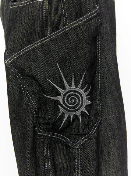 Men's Dale Embroidered Baggy Jeans IL509 black close-up detail of spiral sun embroidery on cargo thigh pocket with contrast white topstitching